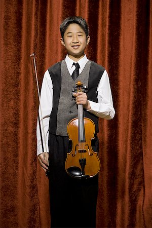 picture of young boy holding violin - Enfant au violon et archet souriant Photographie de stock - Premium Libres de Droits, Code: 640-01574968