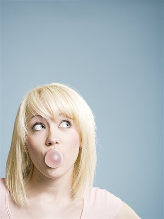 Woman blowing bubbles with chewing gum Stock Photo - Premium Royalty-Free, Code: 640-01575281