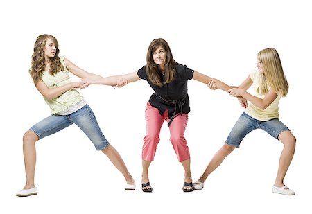 Two girls pulling mother's arms in both directions Stock Photo - Premium Royalty-Free, Code: 640-01601672