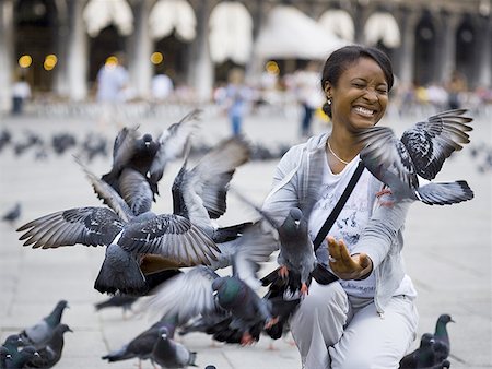 swarm - Woman in public square with pigeons squatting Stock Photo - Premium Royalty-Free, Code: 640-01601780