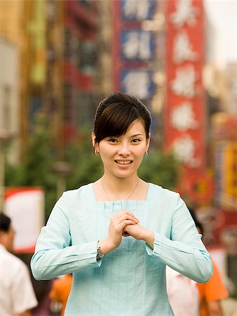 Woman standing on a busy city street bowing. Stock Photo - Premium Royalty-Free, Code: 640-02656306