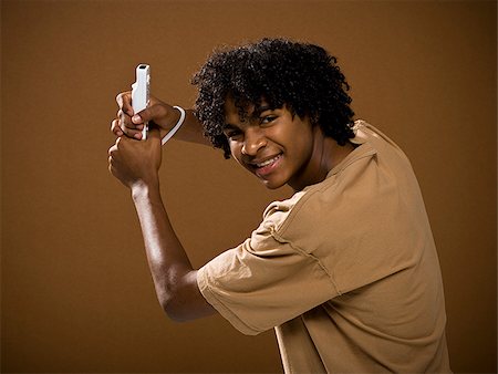 simsearch:640-02776875,k - young man in a brown shirt playing a video game. Stock Photo - Premium Royalty-Free, Code: 640-02656866