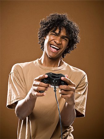 simsearch:640-02776875,k - young man in a brown shirt playing a video game. Stock Photo - Premium Royalty-Free, Code: 640-02656863