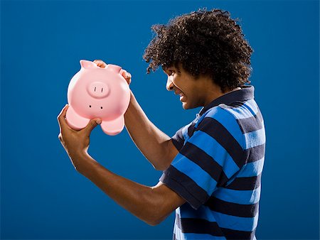 simsearch:640-02776875,k - young man trying to get money out of a piggy bank. Stock Photo - Premium Royalty-Free, Code: 640-02656899