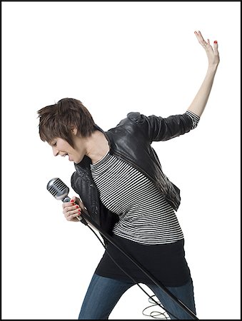 eccentric white background - A young woman singing into a microphone Stock Photo - Premium Royalty-Free, Code: 640-02764807