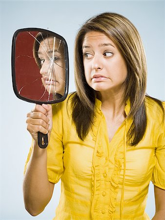 superstition - Woman looking into shattered mirror nervously Stock Photo - Premium Royalty-Free, Code: 640-02765358