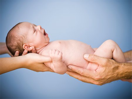 Nouveau-né qui s'est tenue par deux ensembles de mains. Photographie de stock - Premium Libres de Droits, Code: 640-02765433