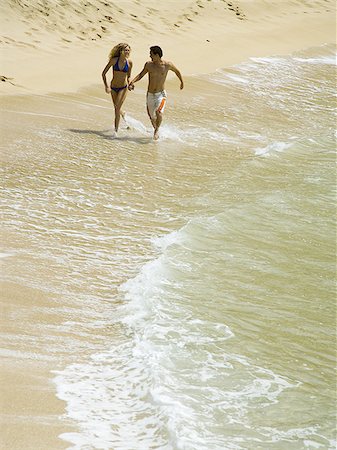 simsearch:625-01098341,k - High angle view of a young couple holding hands and running on the beach Stock Photo - Premium Royalty-Free, Code: 640-02766303