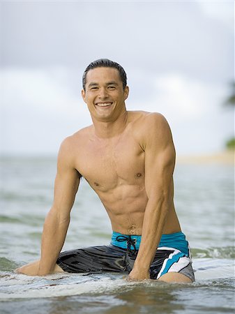 simsearch:625-01098341,k - Portrait of a young man sitting on a surfboard Stock Photo - Premium Royalty-Free, Code: 640-02766386