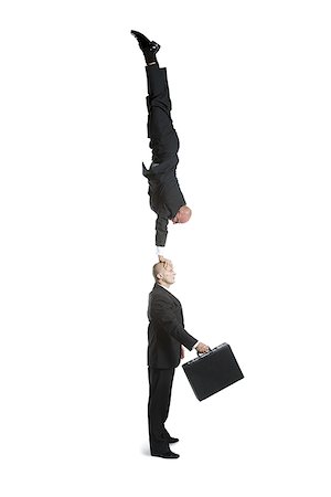 Profile of two male acrobats in business suits performing Stock Photo - Premium Royalty-Free, Code: 640-02766662