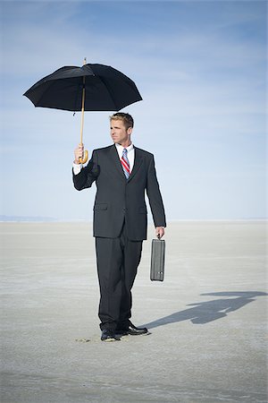 future of the desert - Portrait of a businessman holding an umbrella Stock Photo - Premium Royalty-Free, Code: 640-02766706