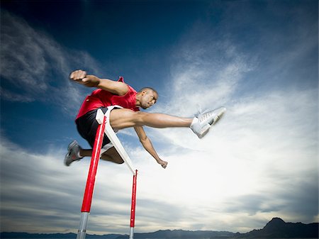 simsearch:640-01361005,k - Low angle view of a young man jumping over a hurdle in a race Stock Photo - Premium Royalty-Free, Code: 640-02766711
