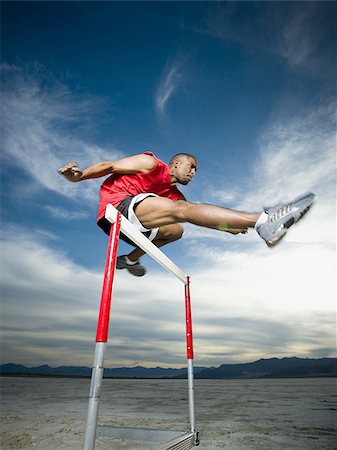 simsearch:640-01361005,k - Low angle view of a young man jumping over a hurdle in a race Stock Photo - Premium Royalty-Free, Code: 640-02766712