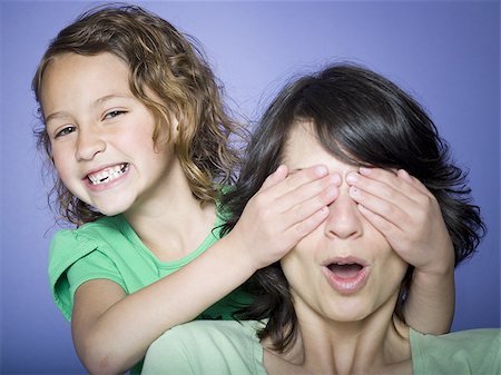 fashion face hair fun - Close-up of a girl covering her mother's eyes Stock Photo - Premium Royalty-Free, Code: 640-02766980