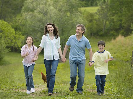 simsearch:640-02767192,k - woman and a man with their son and daughter running in a field Foto de stock - Sin royalties Premium, Código: 640-02767253