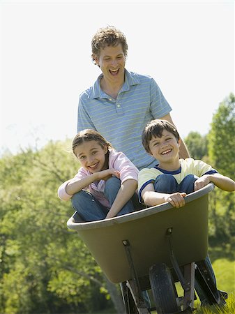 simsearch:640-02767291,k - man pushing his son and daughter in a wheelbarrow Stock Photo - Premium Royalty-Free, Code: 640-02767287