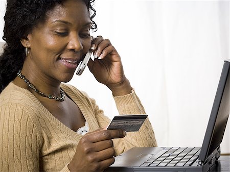 simsearch:640-02767388,k - Profile of a mature woman talking on a mobile phone and holding a credit card Stock Photo - Premium Royalty-Free, Code: 640-02767385