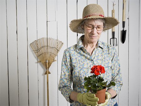 simsearch:640-02768330,k - Portrait of an elderly woman holding a potted flower plant Stock Photo - Premium Royalty-Free, Code: 640-02767396
