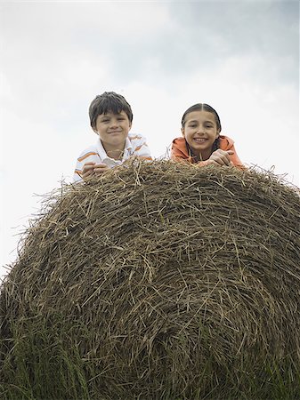 simsearch:632-06030215,k - Portrait of a boy and a girl lying on top of a haystack Stock Photo - Premium Royalty-Free, Code: 640-02767576