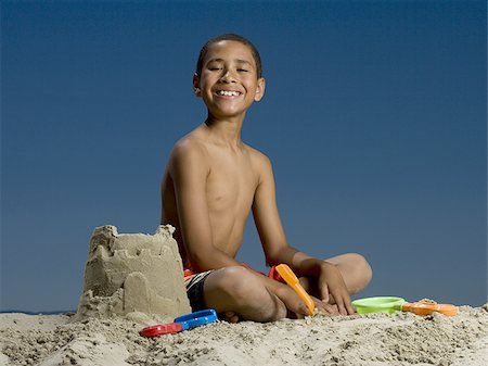 simsearch:625-01748893,k - Portrait of a boy sitting beside a sand castle Stock Photo - Premium Royalty-Free, Code: 640-02767718