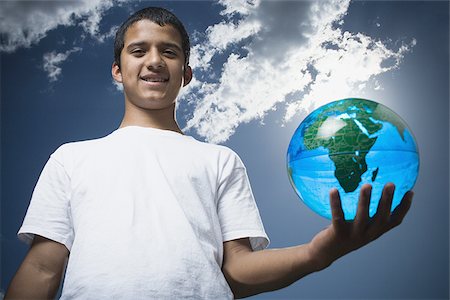 Portrait of a teenage boy holding a globe Stock Photo - Premium Royalty-Free, Code: 640-02767755