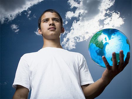 Portrait of a teenage boy holding a globe Stock Photo - Premium Royalty-Free, Code: 640-02767756