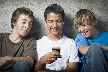 simsearch:640-02767760,k - Gros plan de trois jeunes garçons regardant un lecteur MP3 Photographie de stock - Premium Libres de Droits, Code: 640-02767757