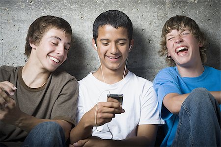 simsearch:640-02767760,k - Gros plan de trois jeunes garçons regardant un lecteur MP3 Photographie de stock - Premium Libres de Droits, Code: 640-02767758