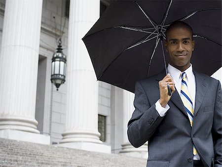 simsearch:640-02767805,k - Portrait of a male lawyer standing in front of a courthouse and holding an umbrella Stock Photo - Premium Royalty-Free, Code: 640-02767784