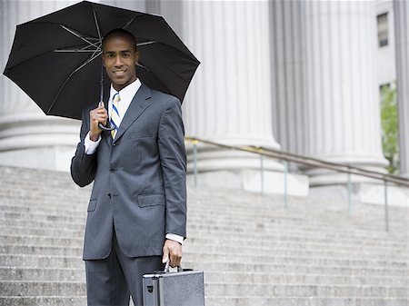 simsearch:640-02767805,k - Portrait of a male lawyer standing in front of a courthouse and holding an umbrella Stock Photo - Premium Royalty-Free, Code: 640-02767785