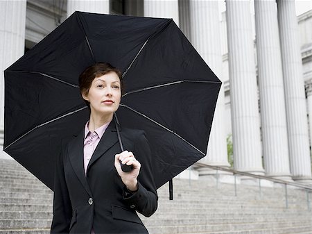 simsearch:640-02767805,k - Portrait of a female lawyer standing on the steps of a courthouse and holding an umbrella Stock Photo - Premium Royalty-Free, Code: 640-02767782