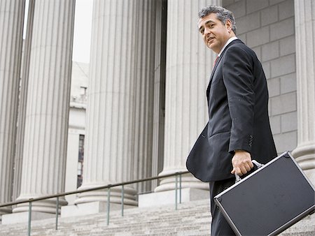 simsearch:640-02767805,k - Low angle view of a male lawyer standing on the steps of a courthouse and smiling Stock Photo - Premium Royalty-Free, Code: 640-02767814