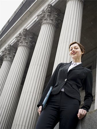 simsearch:640-02767805,k - Low angle view of a female lawyer holding a file and smiling Stock Photo - Premium Royalty-Free, Code: 640-02767812