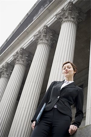 simsearch:640-02767805,k - Low angle view of a female lawyer holding a file and smiling Stock Photo - Premium Royalty-Free, Code: 640-02767813