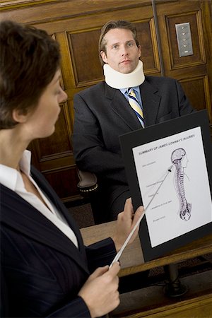 simsearch:640-01351636,k - A female lawyer pointing at evidence in front of a victim in a courtroom Foto de stock - Sin royalties Premium, Código: 640-02767886