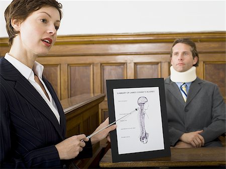simsearch:640-01351636,k - A female lawyer pointing at evidence in front of a victim in a courtroom Stock Photo - Premium Royalty-Free, Code: 640-02767887