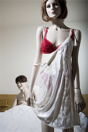 puff - Close-up of a female mannequin half dressed with a male mannequin laughing on the bed behind Foto de stock - Sin royalties Premium, Código: 640-02768360