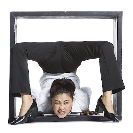 Female contortionist businesswoman inside the box Stock Photo - Premium Royalty-Free, Code: 640-02768595