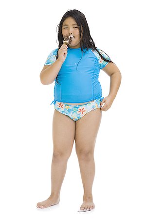 Overweight young girl eating ice cream bar Stock Photo - Premium Royalty-Free, Code: 640-02769665