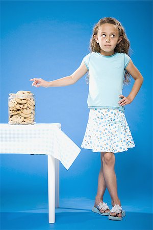sneak - Girl sneaking Chocolate Chip Cookie from cookie jar Stock Photo - Premium Royalty-Free, Code: 640-02774392