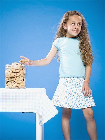 sneak - Girl sneaking Chocolate Chip Cookie from cookie jar Stock Photo - Premium Royalty-Free, Code: 640-02774393