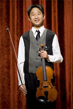 picture of young boy holding violin - Garçon avec violon et archet souriant Photographie de stock - Premium Libres de Droits, Code: 640-02774470