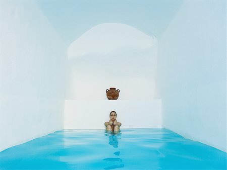 simsearch:640-02774951,k - Woman sitting in pool with knees up under clay urn Stock Photo - Premium Royalty-Free, Code: 640-02774932