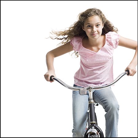 Girl riding bicycle smiling Stock Photo - Premium Royalty-Free, Code: 640-02775324