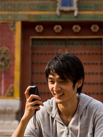 simsearch:640-03260747,k - Teenage boy outdoors with cell phone smiling Stock Photo - Premium Royalty-Free, Code: 640-02775504