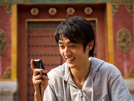 simsearch:640-03260747,k - Teenage boy outdoors with cell phone smiling Stock Photo - Premium Royalty-Free, Code: 640-02775500