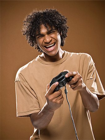 simsearch:640-02776875,k - young man in a brown shirt playing a video game. Stock Photo - Premium Royalty-Free, Code: 640-02776869