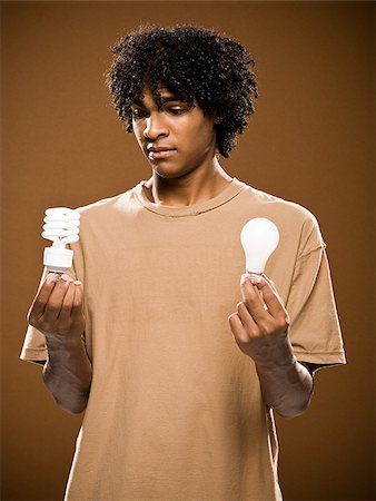 simsearch:640-02776875,k - young man in a brown shirt holding light bulbs. Stock Photo - Premium Royalty-Free, Code: 640-02776878