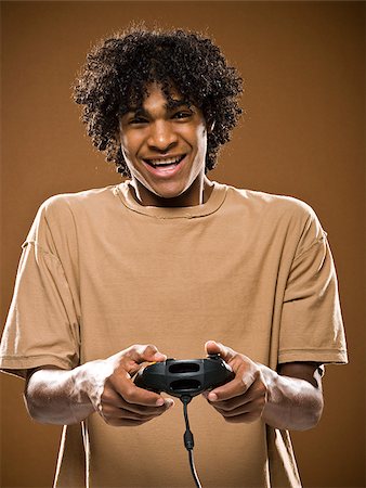 simsearch:640-02776875,k - young man in a brown shirt playing a video game. Stock Photo - Premium Royalty-Free, Code: 640-02776870