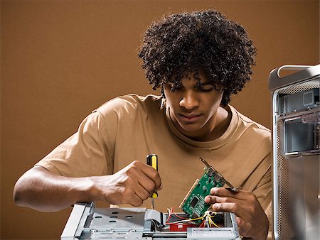 simsearch:640-02776875,k - young man in a brown shirt fixing a computer. Stock Photo - Premium Royalty-Free, Code: 640-02776886